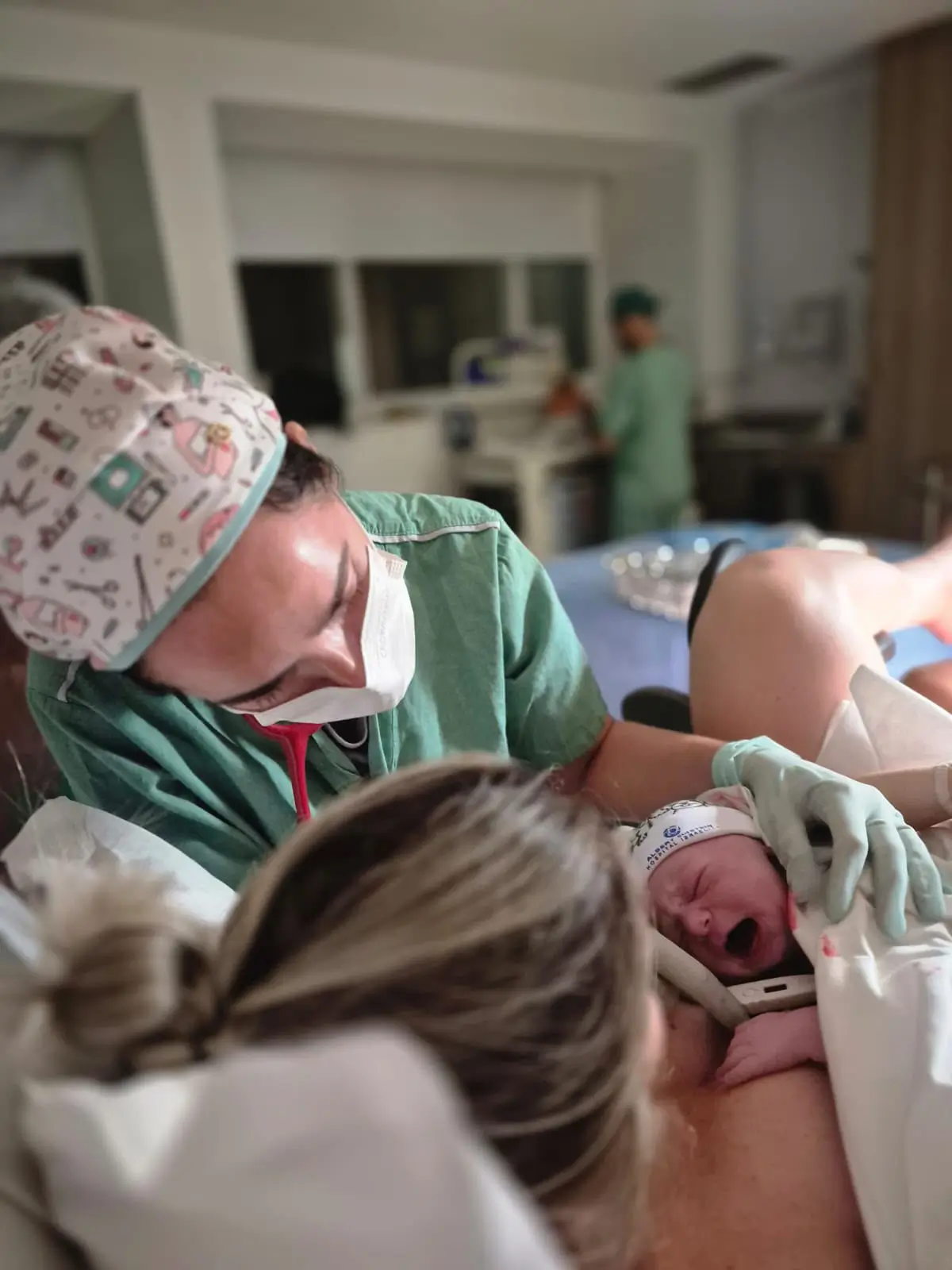 Dra. Vanessa Mouawad recepcionando um recém-nascido logo após o parto, ao lado da mãe