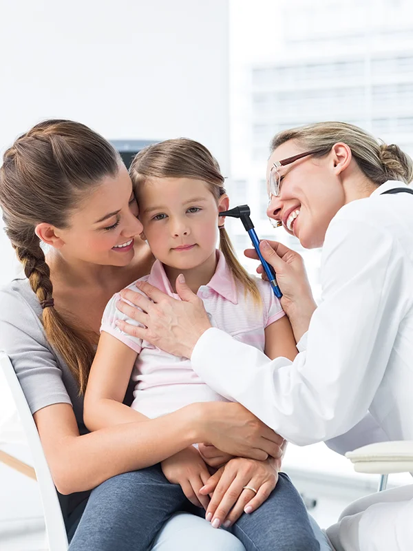 Mãe segurando a filha durante avaliação pediátrica